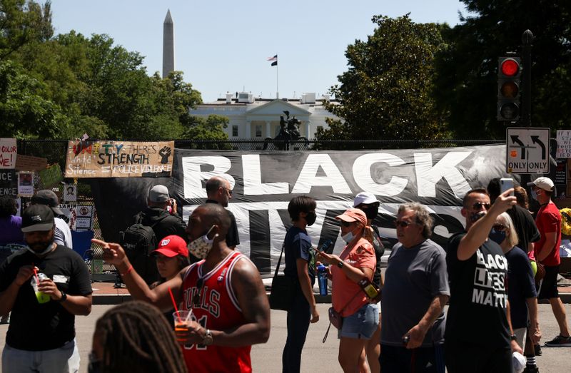 © Reuters. People gather to view protest signs now affixed to the fence around Lafayette Square at the scene where protesters clashed with police near the White House in Washington