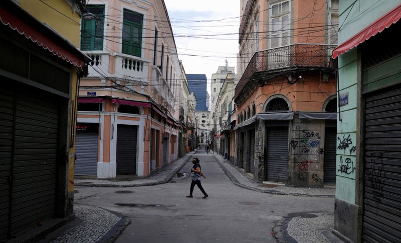 © Reuters. Mulher caminha por ruas vazias com comércio fechado no Rio de Janeiro (RJ), em meio à pandemia de coronavírus