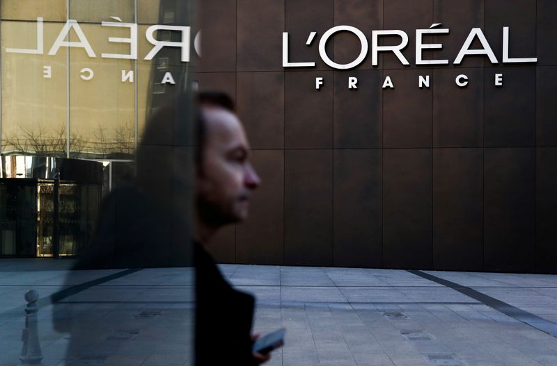 &copy; Reuters. FILE PHOTO: A man walks by the logo of French cosmetics group L&apos;Oreal in the western Paris suburb of Levallois-Perret