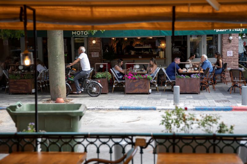 &copy; Reuters. Customers sit at a coffee shop as some businesses reopened at the end of last month under a host of new rules, following weeks of shutdown amid the coronavirus disease (COVID-19) crisis, in Tel Aviv, Israel