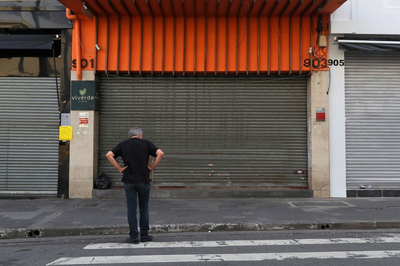 © Reuters. Homem em frente a lojas fechadas em São Paulo (SP) durante a pandemia de coronavírus