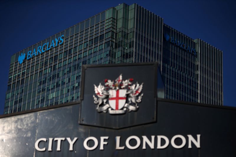 &copy; Reuters. FILE PHOTO: Barclays&apos; building in Canary Wharf is seen behind a City of London sign outside Billingsgate Market in London