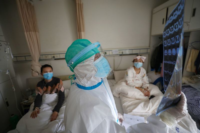 © Reuters. Médico observa exames de pacientes em hospital de Wuhan, na China, em meio à pandemia de coronavírus