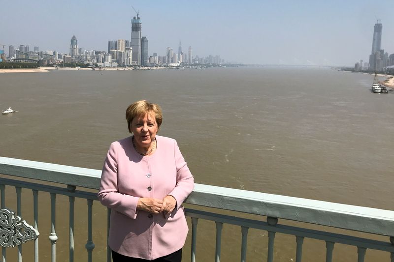 © Reuters. FILE PHOTO: German Chancellor Angela Merkel poses for pictures on a bridge crossing the Yangtze River in Wuhan