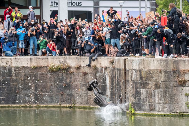 © Reuters. The statue of Edward Colston falls into the water after protesters pulled it down in Bristol