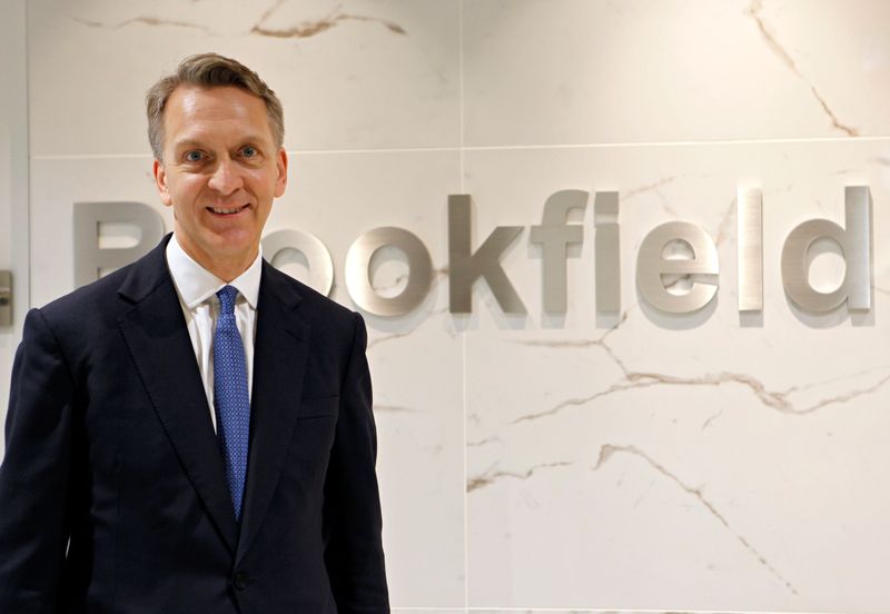 &copy; Reuters. Bruce Flatt, CEO of Brookfield Asset Management, poses in front of the company&apos;s logo in Tokyo