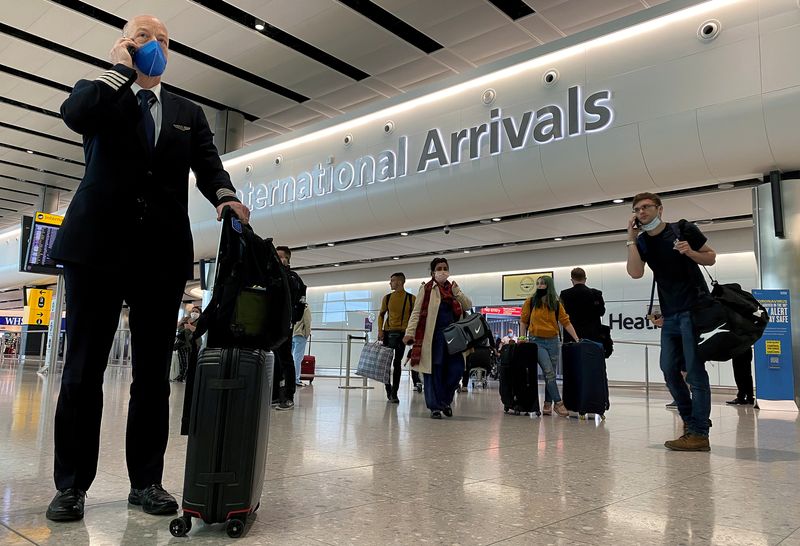 © Reuters. FILE PHOTO: A member of aircrew is seen wearing a protective  face mask at Heathrow Airport, as Britain launches its 14-day quarantine for international arrivals, following the outbreak of the coronavirus disease (COVID-19), London, Britain