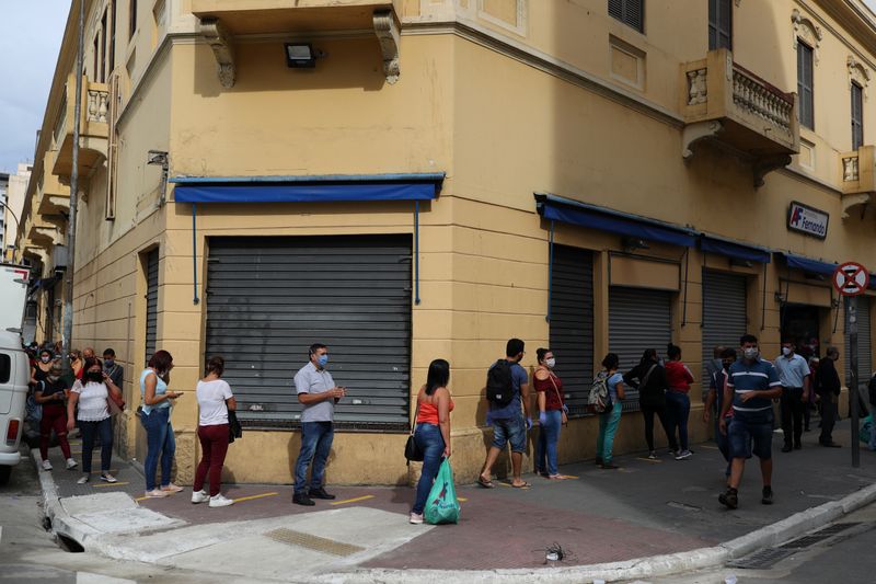 &copy; Reuters. Foto del miércoles de un grupo de personas haciendo fila para comprar en un comercio en Sao Paulo, en medio del alivio a las restricciones por la pandemia de coronavirus