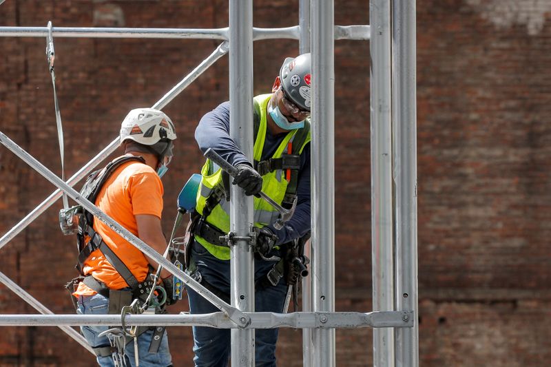 © Reuters. FILE PHOTO: Construction workers assemble a scaffold at a job site, as phase one of reopening after lockdown begins, during the outbreak of the coronavirus disease (COVID-19) in New York