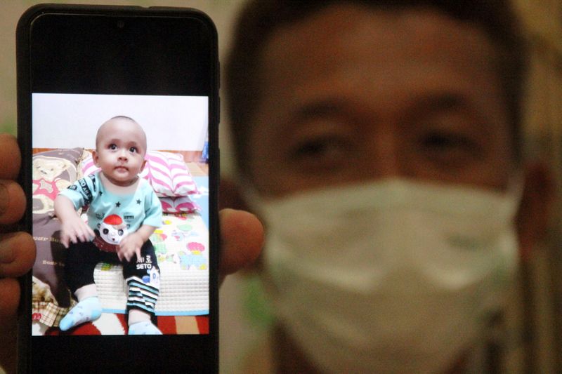 &copy; Reuters. Iyansyah, 45, shows on his phone a picture of his child Fahri, who died from coronavirus disease (COVID-19) at the age of nine months in a private hospital that did not have any care for children amid the outbreak, in Mataram