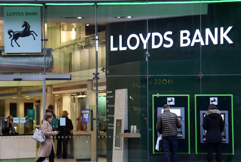 © Reuters. FILE PHOTO: Customers use ATMs at a branch of Lloyds Bank in London