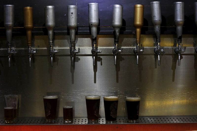 &copy; Reuters. FILE PHOTO: Glasses of craft beer are placed underneath beer taps at a microbrewery in Beijing