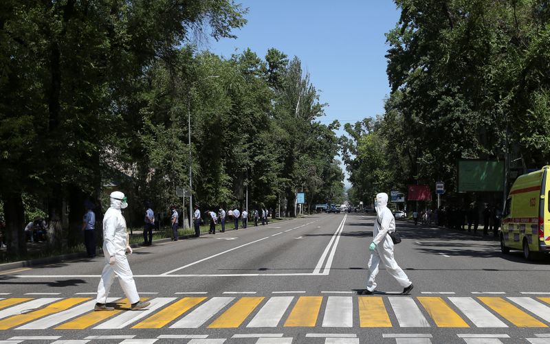 &copy; Reuters. Специалисты в защитных костюмах в Алма-Ате