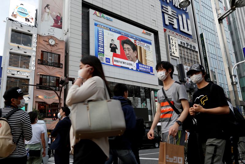 © Reuters. A large screen on a building shows live broadcast of Japan's Prime Minister Shinzo Abe's news conference at Shinjuku district in Tokyo