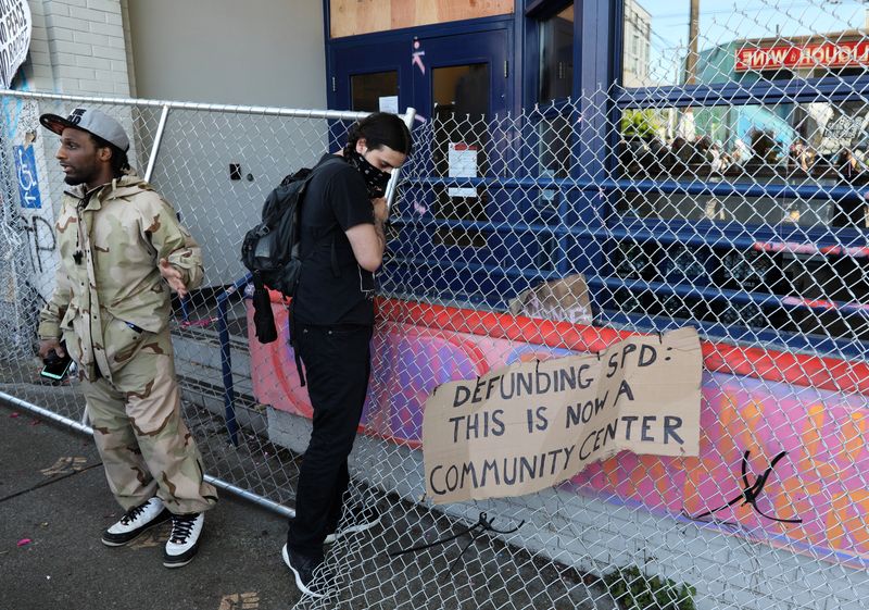 © Reuters. A protester sets up a barricade in front of an entrance of Seattle Police Department East Precinct during a protest against racial inequality and call for defunding of Seattle police, in Seattle