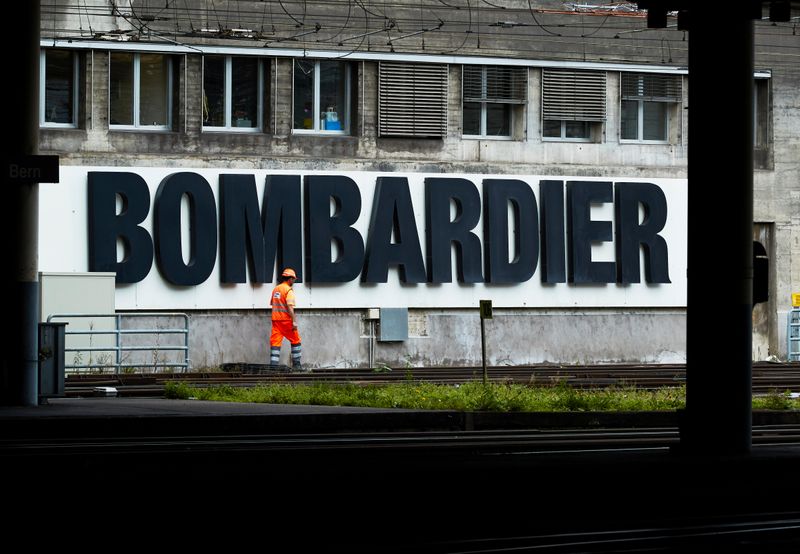 © Reuters. A worker walks in front of a Bombardier advertising board at the SBB CFF Swiss railway train station in Bern