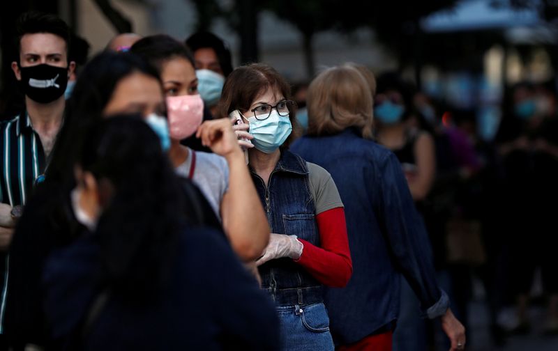 &copy; Reuters. Imagen de archivo de gente usando mascarilla mientras hace fila para entrar a una tienda Primark que reabrió en Madrid luego de la flexibilización de las medidas de confinamiento para contener la pandemia de COVID-19