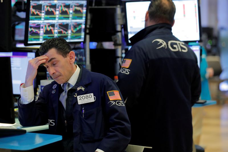 &copy; Reuters. FILE PHOTO: Traders work on the floor of the New York Stock Exchange (NYSE) as the building prepares to close indefinitely due to the coronavirus disease (COVID-19) outbreak in New York