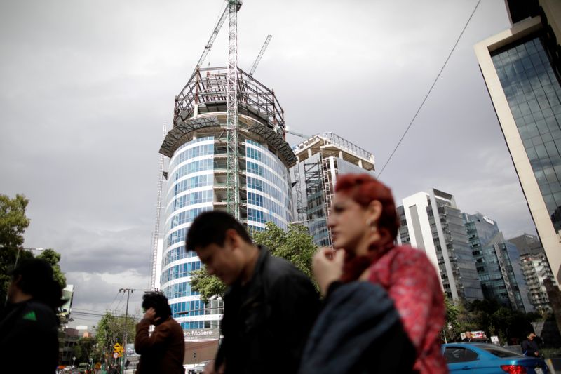 &copy; Reuters. People walk past a building undergoing construction in Mexico City