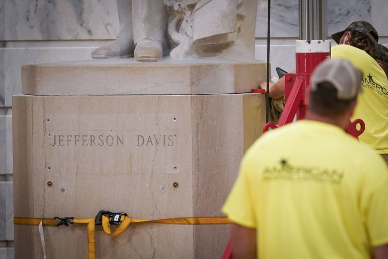 © Reuters. Workers prepare to remove a stature of Confederate President Jefferson Davis form the rotunda of the State Capitol in Frankfort