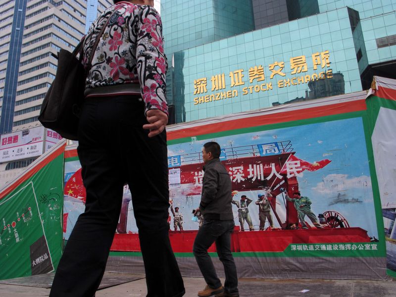 &copy; Reuters. FILE PHOTO:  Passers-by walk on a footbridge in front of the Shenzhen Stock EXchange