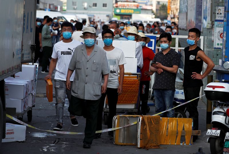 &copy; Reuters. People are wearing face masks inside the Jingshen seafood market which has been closed for business after new coronavirus infections were detected, in Beijing