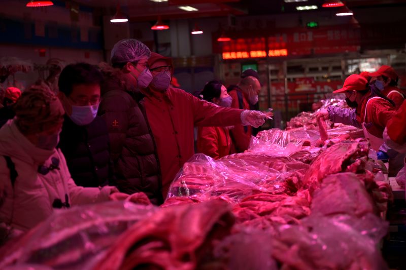 © Reuters. Customers wearing face masks buy pork meat at the Xinfadi wholesale market, as the country is hit by an outbreak of the novel coronavirus disease (COVID-19), in Beijing