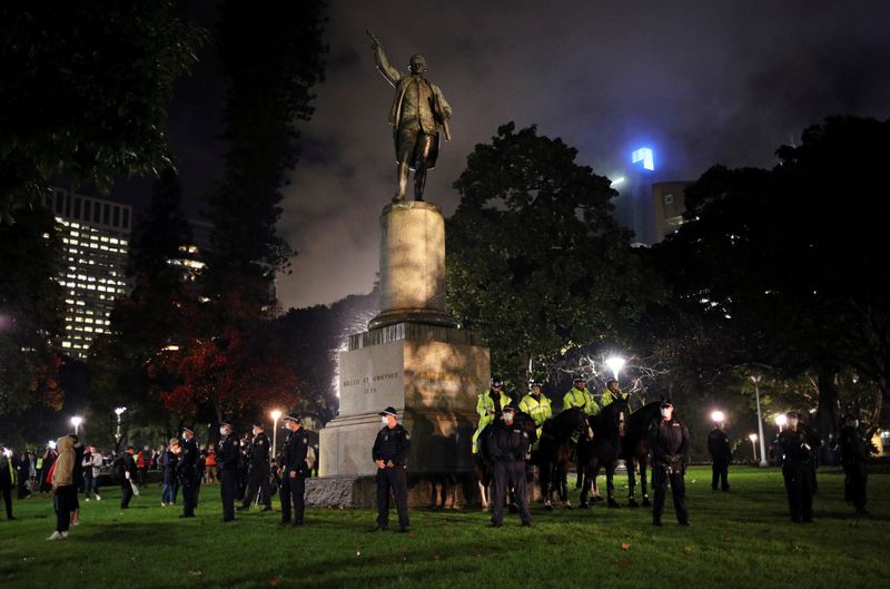 © Reuters. Police officers stand guard around the statue of British explorer Captain James Cook as they deter demonstrators from taking part in a protest in solidarity with the Black Lives Matter protests, in Sydney