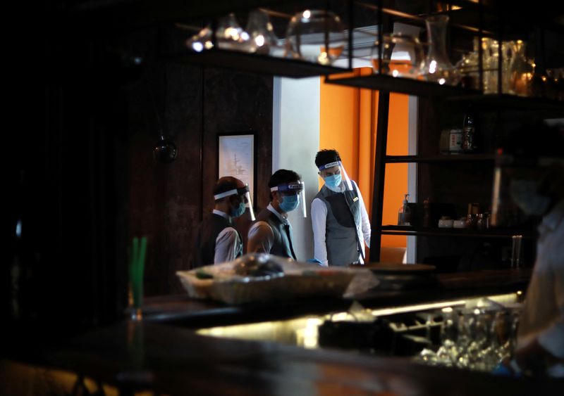 © Reuters. Los servidores que usan protectores faciales se ven en un restaurante mientras India en Nueva Delhi