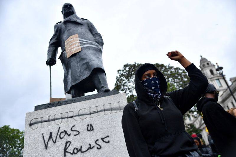 &copy; Reuters. FOTO DE ARCHIVO. Un manifestante protesta junto a un grafiti al lado de la estatua de  Winston Churchill en el centro de Londres. Junio, 2020. REUTERS/Dylan Martinez