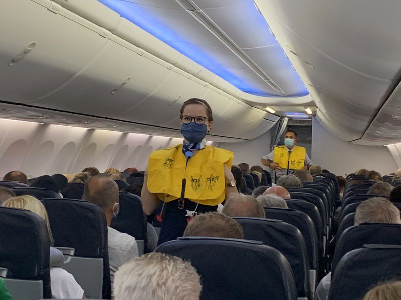 &copy; Reuters. Las azafatas de TUI Fly usan mascarillas mientras dan instrucciones a los turistas alemanes en el primer vuelo de Dusseldorf a Mallorca en Dusseldorf, Alemania, el 15 de junio de 2020