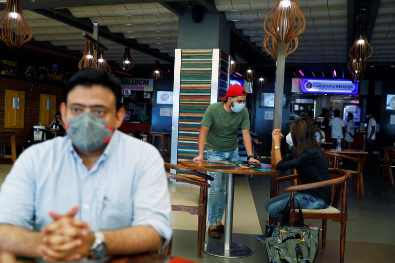 &copy; Reuters. Pessoas usam máscaras de proteção em praça de alimentação em shopping de Nova Délhi