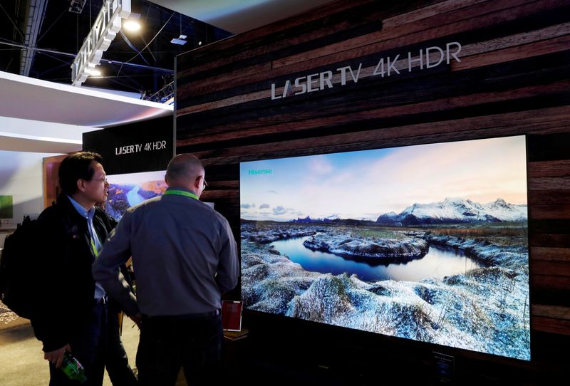 © Reuters. FILE PHOTO: Attendees look over a 4K laser television in the Hisense booth during the 2019 CES in Las Vegas