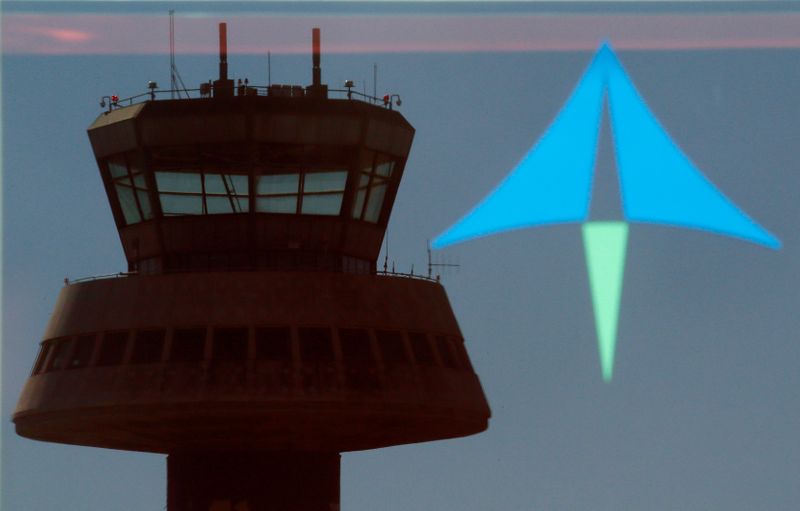 © Reuters. Una torre de control se refleja en una puerta de cristal junto a un logo de AENA en el aeropuerto de Barcelona el 10 de febrero de 2015