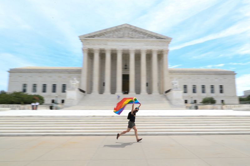 &copy; Reuters. Joseph Fons sostiene una bandera del Orgullo mientras corre delante del edificio de la Corte Suprema de Estados Unidos, después de que el tribunal dictaminó que una ley federal que prohíbe la discriminación en el lugar de trabajo también cubre la ori