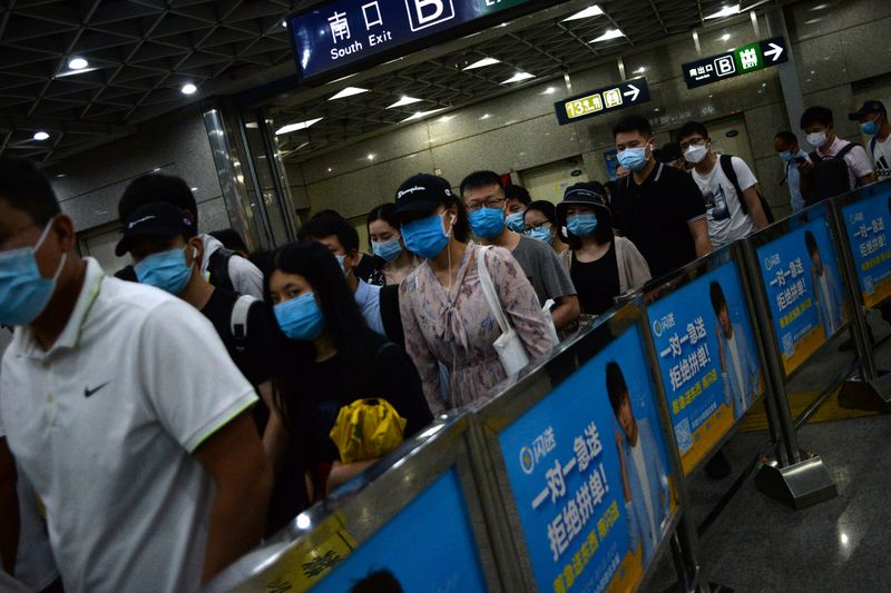 &copy; Reuters. People wearing face masks commute inside a subway station during morning rush hour, following new cases of coronavirus disease (COVID-19) infections in Beijing