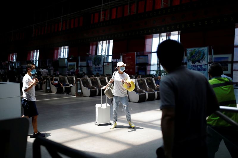 &copy; Reuters. Пассажиры в защитных масках в аэропорту Сичан Циншань в Сичане