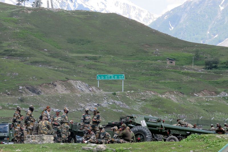 © Reuters. Indian army soldiers rest next to artillery guns at a makeshift transit camp before heading to Ladakh, near Baltal