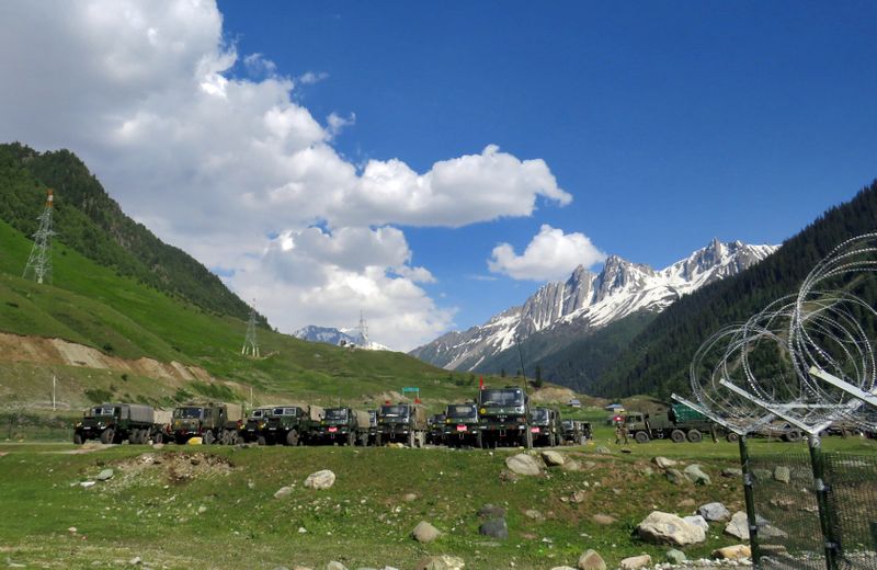 © Reuters. Indian army soldiers walk past their parked trucks at a makeshift transit camp before heading to Ladakh, near Baltal