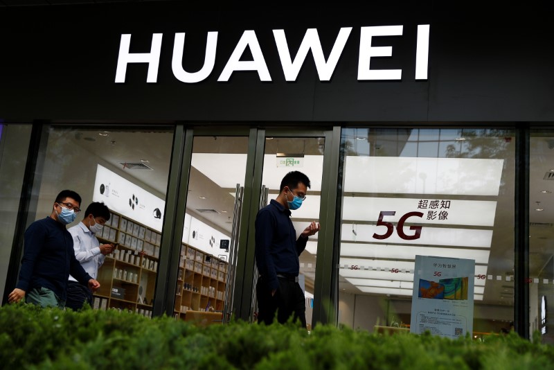 &copy; Reuters. People walk past a Huawei shop, amid an outbreak of the coronavirus disease (COVID-19), in Beijing