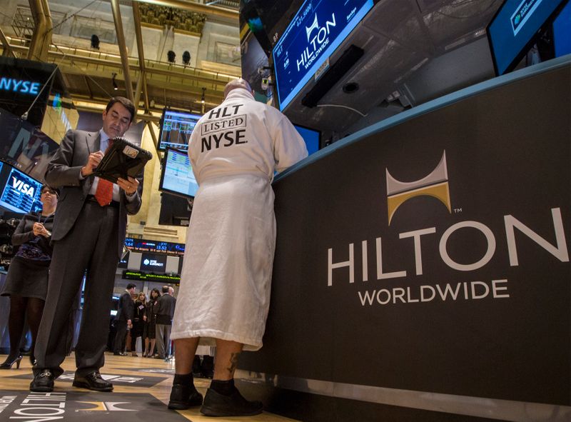 &copy; Reuters. Specialist Trader John O&apos;Hara wears a Hilton branded bathrobe to celebrate Hilton&apos;s IPO, while working at his post on the floor of the New York Stock Exchange