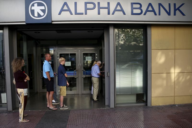 &copy; Reuters. FILE PHOTO: People line up at an ATM outside an Alpha Bank branch in Athens