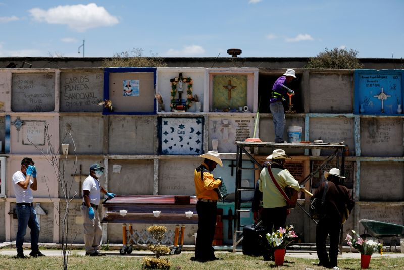 &copy; Reuters. FOTO DE ARCHIVO: Trabajadores funerarios junto al ataúd de una mujer que murió de la enfermedad coronavirus (COVID-19), mientras los músicos están de pie junto a ellos en el cementerio municipal de Nezahualcoyotl, Estado de México, México.