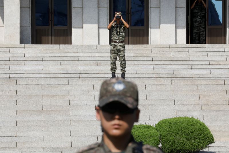 &copy; Reuters. A North Korean soldier looks toward the south as a South Korean soldier stands guard in the truce village of Panmunjom