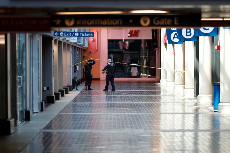 © Reuters. FILE PHOTO: Amtrak Police officers pass under caution tape while on patrol at Washington Union Station, following Mayor Muriel Bowser's state of emergency declaration due to the coronavirus disease (COVID-19), in Washington