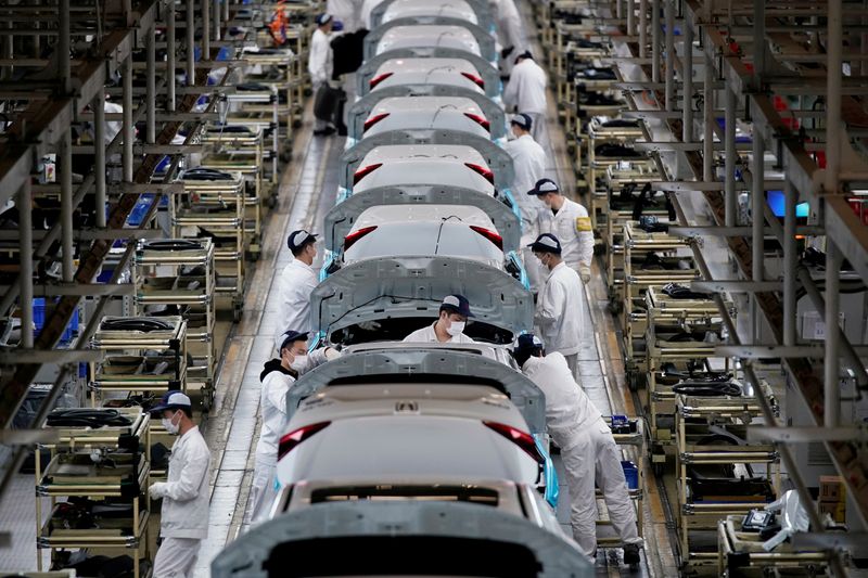 © Reuters. FILE PHOTO: Employees work on a production line inside a Dongfeng Honda factory in Wuhan