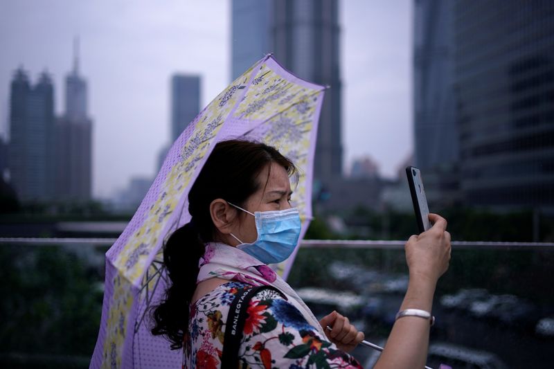 &copy; Reuters. Женщина в медицинской маске в Шанхае