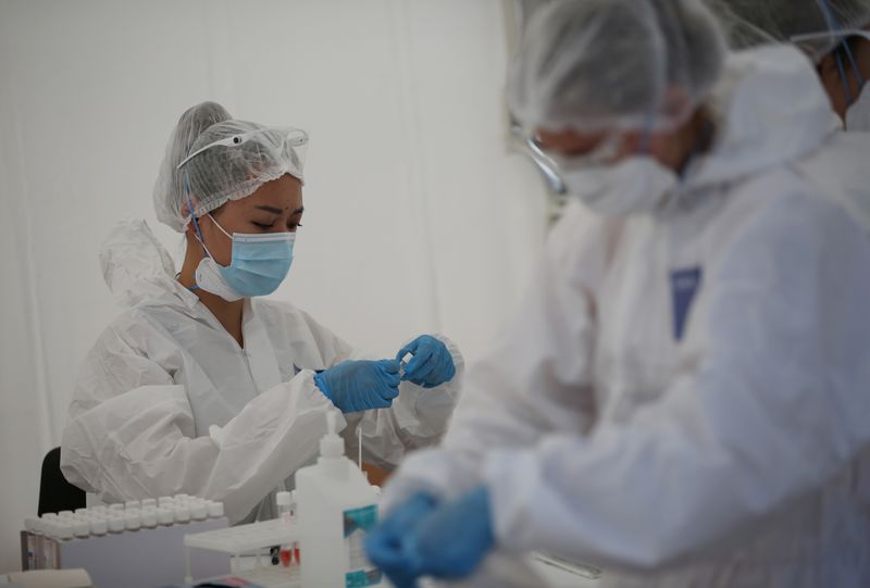 &copy; Reuters. Медицинские работники на мобильной станции для проведения тестирования на коронавирус в Алма-Ате