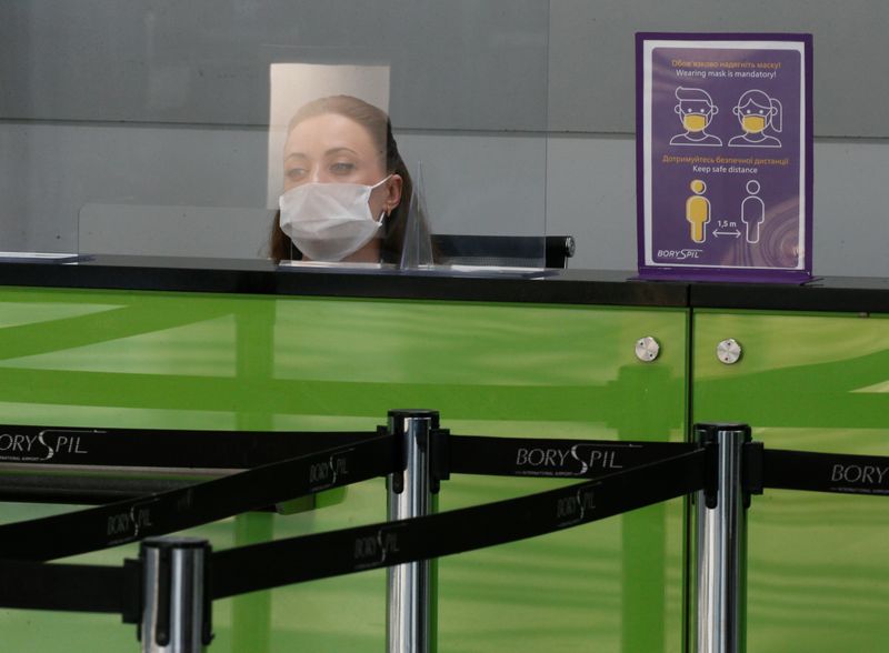 &copy; Reuters. Сотрудница в защитной маске за информационной стойкой в аэропорту Борисполь под Киевом