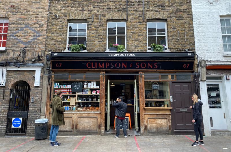 &copy; Reuters. FILE PHOTO: People observe social distancing rules outside Climpson &amp; Sons coffee shop in Hackney